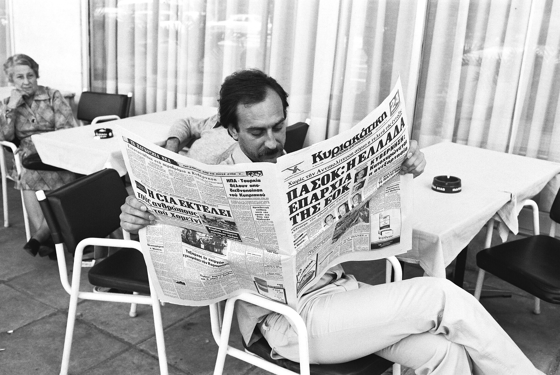 Scenes of everyday life in Athens, Greece. A man reading a newspaper at a café terrace (28.05.1979), Jean-Louis Debaize, Audiovisual Service of the European Commission, Wikimedia Commons.